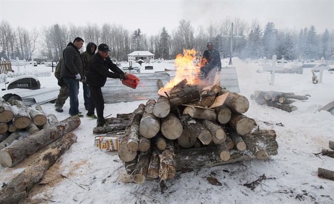 Gerald Moise, father of shooting victim Dayne Fontaine, 17, pours gas on a fire prepares to soften the ground to dig a grave in La Loche, Sask., Monday, Jan. 25, 2016. A seventeen-year-old boy allegedly shot and killed Moise and three others. THE CANADIAN PRESS/Jonathan Hayward