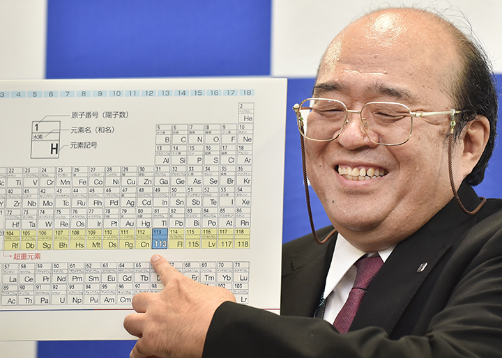Kosuke Morita, the leader of the Riken team, smiles as he points to a board displaying the new atomic element 113 during a press conference in Wako, Saitama prefecture on December 31, 2015. 