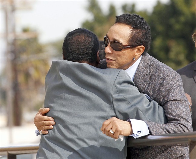 Singer Smokey Robinson, right, embraces an unidentified man as he arrives for the funeral of singer Natalie Cole at West Angeles Church of God in Christ in the Crenshaw district of Los Angeles, Monday, Jan. 11, 2016.