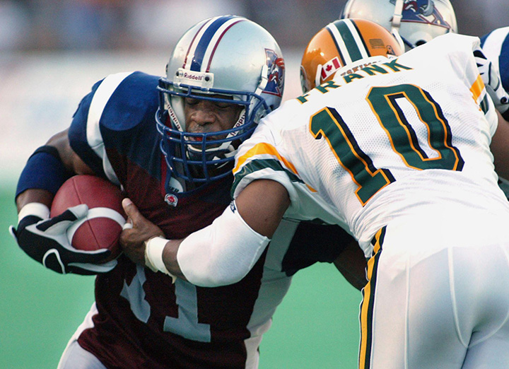 Montreal Alouettes running back Lawrence Phillips is tackled by Edmonton Eskimos corner back Malcolm Frank during first quarter CFL action in this Friday, Aug. 2, 2002 file photo. 