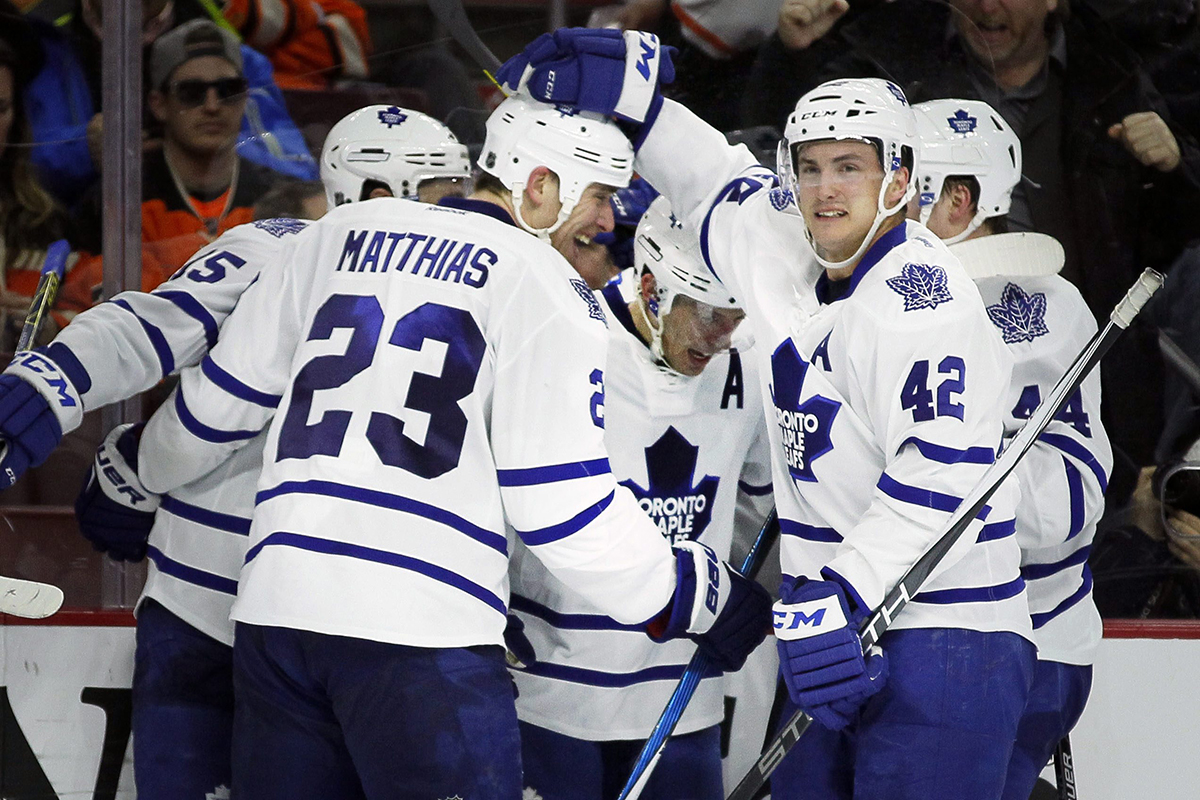 Toronto Maple Leafs' Matt Hunwick, center, is swarmed by teammats celebrating his game-winning goal with 7.5 seconds lef.