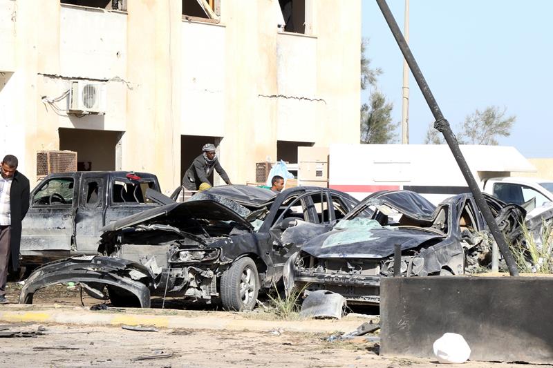 Libyan onlookers inpect damaged cars at the site of a suicide truck bombing on a police school in Libya's coastal city of Zliten, some 170 kilometres (100 miles) east of the capital Tripoli, which killed at least 50 people on January 7, 2015, in the deadliest attack to hit the strife-torn country since its 2011 revolution.