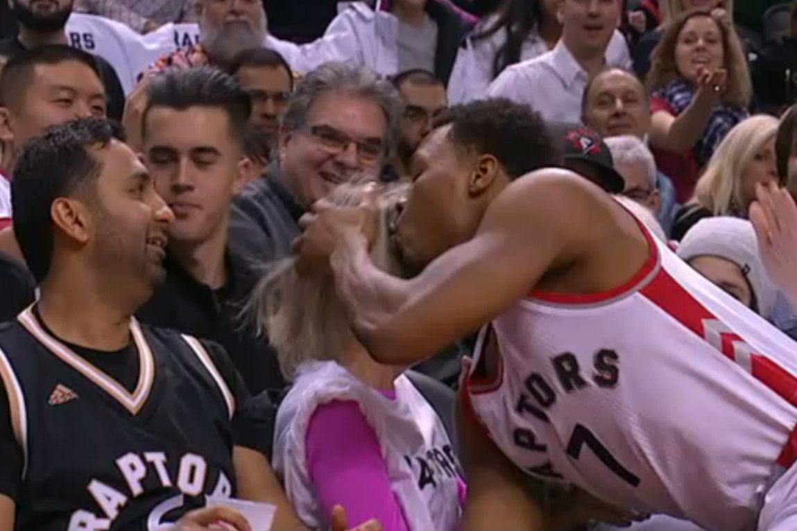 Kyle Lowry kisses a fan after crashing into her during Friday's game against Miami.
