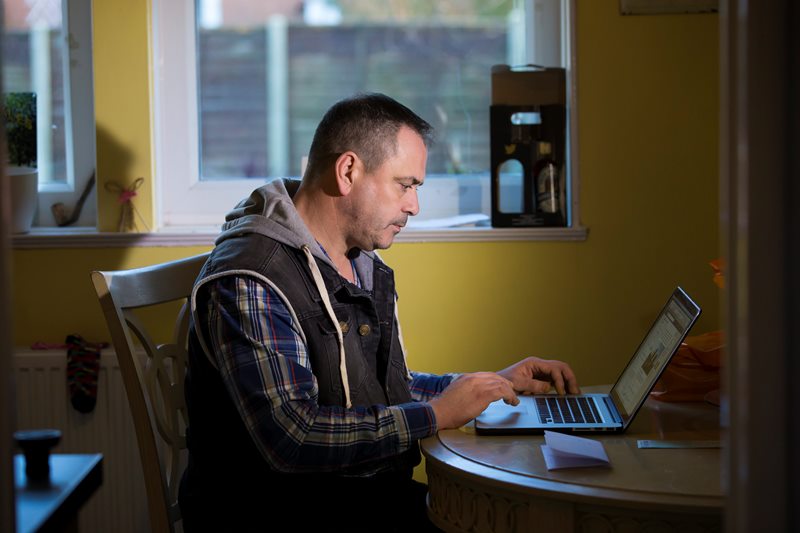 Former British soldier Rob Lawrie sits by a computer after an interview with the Associated Press in Guiseley, England, Friday Jan. 8, 2016.