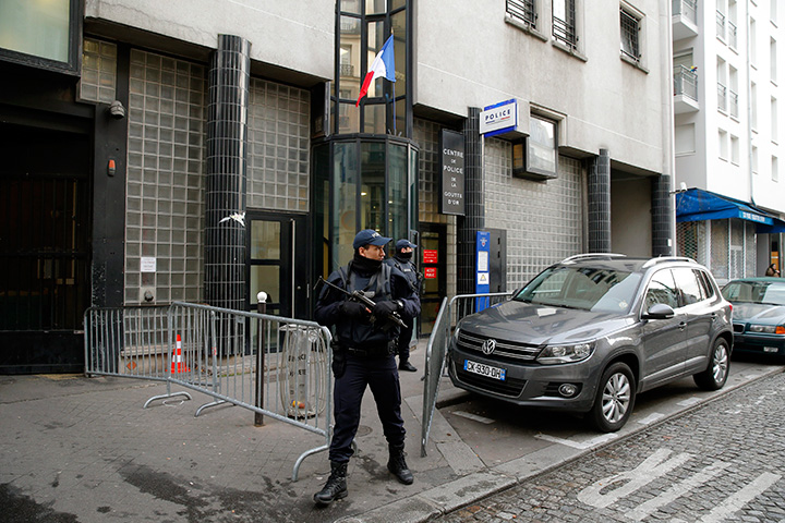 An officer stands guard in front of the police station where a man was killed Thursday after he showed up wearing fake explosives, in Paris, Friday, Jan. 8, 2016. 