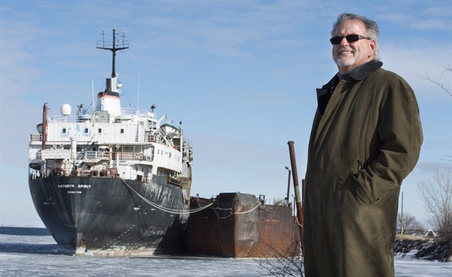 Beauharnois mayor Claude Haineault stands next to the Kathryn Spirit Wednesday, January 27, 2016 in Beauharnois, Que. Concerns are that the derelict cargo ship anchored off the town's shore could sink, spilling toxic material into Montreal's drinking water supply.