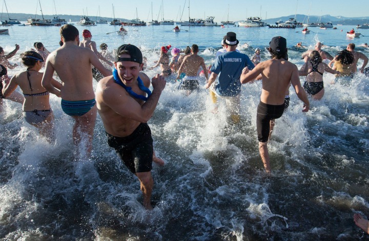 Participants splash in the frigid waters of English Bay during the 96th annual Polar Bear Swim in Vancouver, B.C., on Friday January 1, 2016. The event, hosted by the Vancouver Polar Bear Swim Club, held it's first swim on New Year's Day in 1920. 