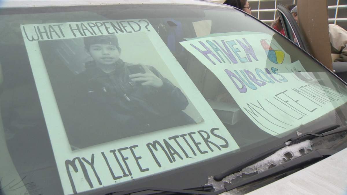 Posters cover the windshield of Richelle Dubois’ van, parked outside Regina Police headquarters.