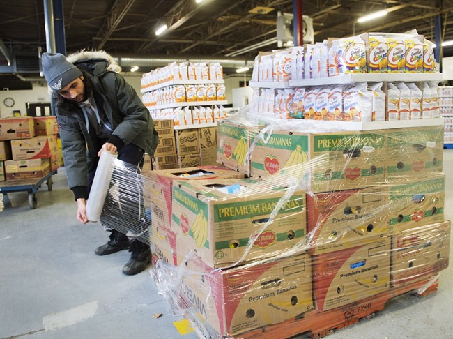 Artem Mousessian wraps a shipment for delivery at the distribution centre for Moisson Montreal, the largest food bank in Canada, Thursday, January 28, 2016 in Montreal. Canadian food banks hope that the pinch they're feeling from rising food prices isn't snowballing into a full-fledged crisis.