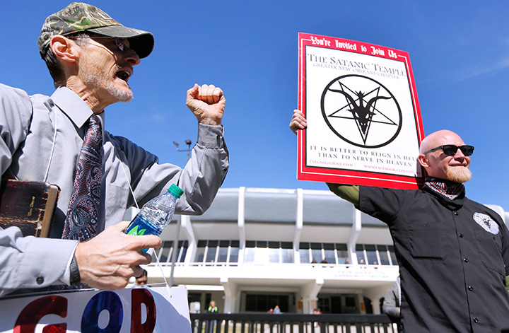 In this January 24, 2015 file photo, a member of The Satanic Temple protests outside of an all-day prayer rally in Baton Rouge, La.