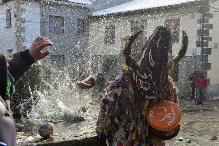 People throw turnips to Jarramplas as he walks the streets of the Spanish village of Piornal playing a drum, during the Jarramplas' Festival on January 20, 2015.