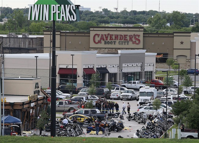 In this May 17, 2015 file photo, authorities investigate a shooting in the parking lot of Twin Peaks restaurant in Waco, Texas. An indictment announced by the U.S. Attorney's Office in San Antonio accuses three Bandidos leaders of sanctioning a three-year fight that included violent clashes with rival gangs and distribution of methamphetamine. The accusations focus on a rivalry that came under renewed attention in May, when a meeting of biker groups at a Twin Peaks restaurant in Waco, Texas, ended in gunfire that left nine people dead.
