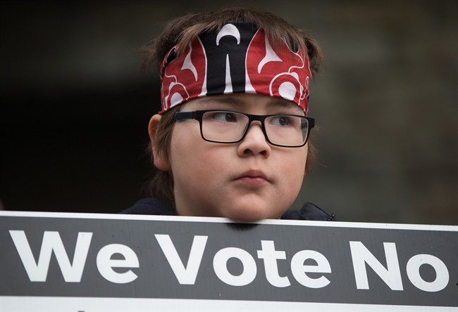 FILE PHOTO: Jamie Antone, 9, of the Squamish First Nation, holds a sign as protesters gather outside National Energy Board hearings on the proposed Trans Mountain pipeline expansion in Burnaby, B.C., on January 19, 2016.