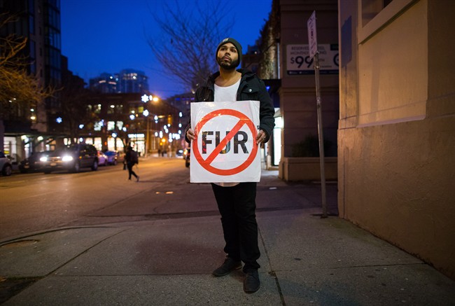 Taylor Freeman holds a sign while standing for a photograph before participating in an anti-fur protest outside a clothing store in Vancouver, B.C., on Thursday January 7, 2016. Freeman received a warning letter from Vancouver police in November that he would be charged with criminal harassment if he continued protesting outside Snowflake Furs, a different store than the one near where he was photographed. 