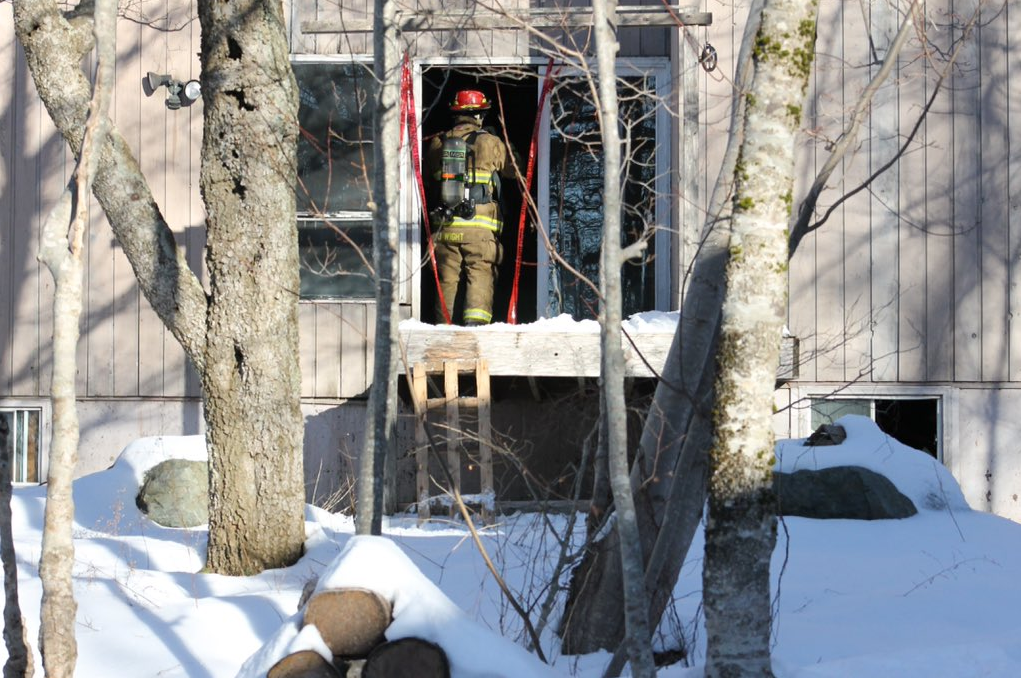A firefighter enters a home in Waverley during the investigation of a fire on Wednesday morning.