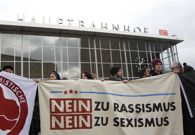 People protest in front of the main station in Cologne, Germany, on Wednesday, Jan. 6, 2016. The poster reads: "No to Racism, No to Sexism". 