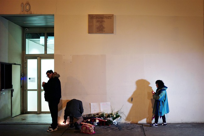 Locals place flowers outside of the former offices of Charlie Hebdo. (Associated Press)