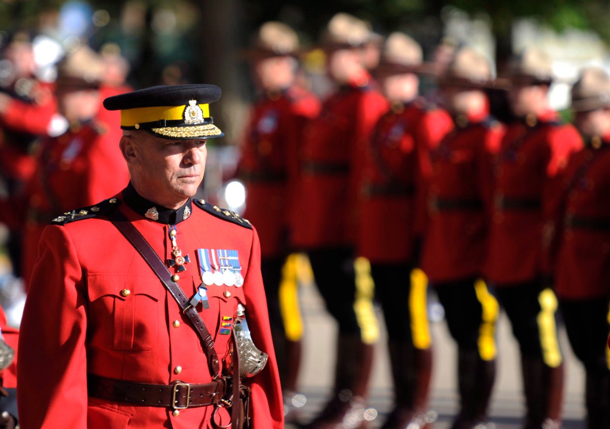 RCMP Commissioner Bob Paulson, left, inspects officers during a memorial for RCMP officers who died in the line of duty in Regina, Sask., on Sunday, September 13, 2015. 