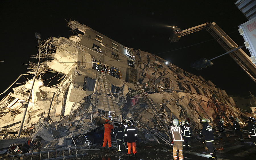 Rescue workers search a toppled building after an earthquake in Tainan, Taiwan, Saturday, Feb. 6, 2016.