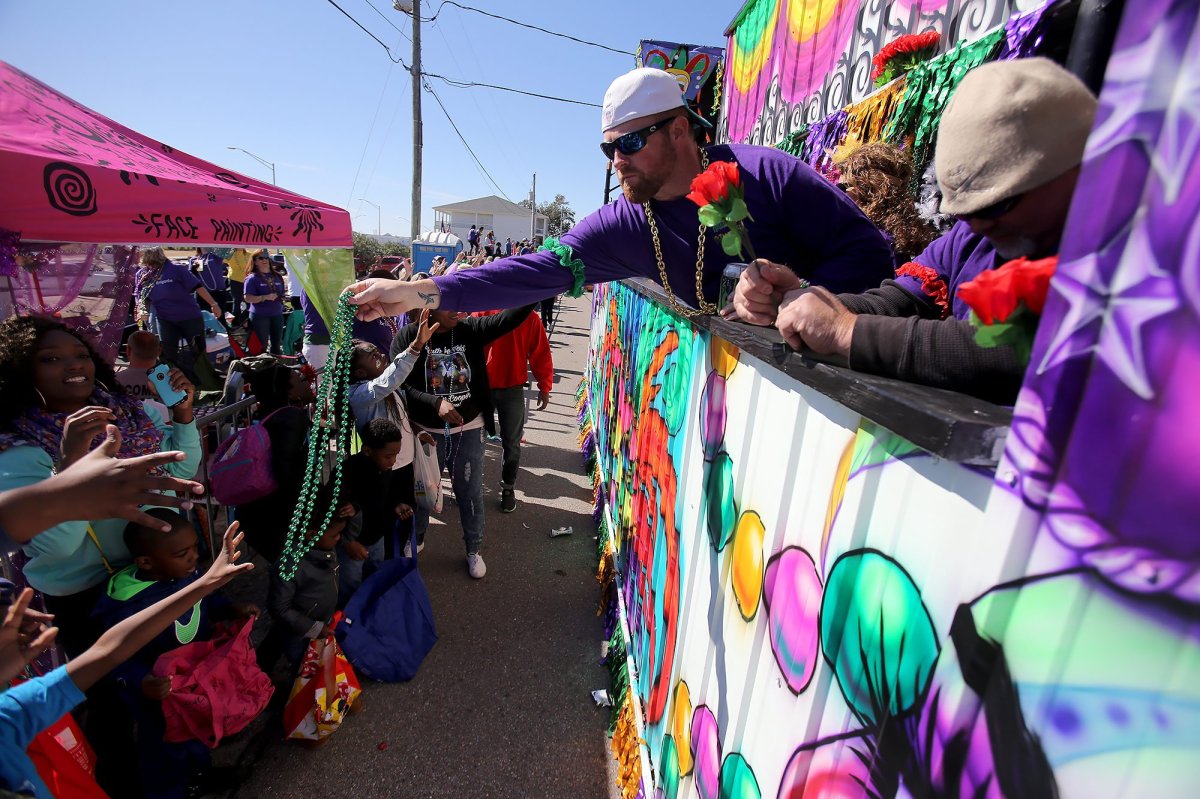Float riders hand out beads to the crowd as the St. Paul Carnival Association parade rolls through downtown Pass Christian, Miss., Sunday, Feb. 7, 2016. 