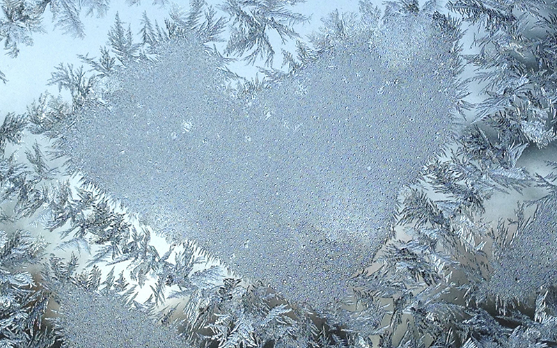 File - Frost on a window forms a heart-shaped pattern on Friday, Feb. 12, 2016.