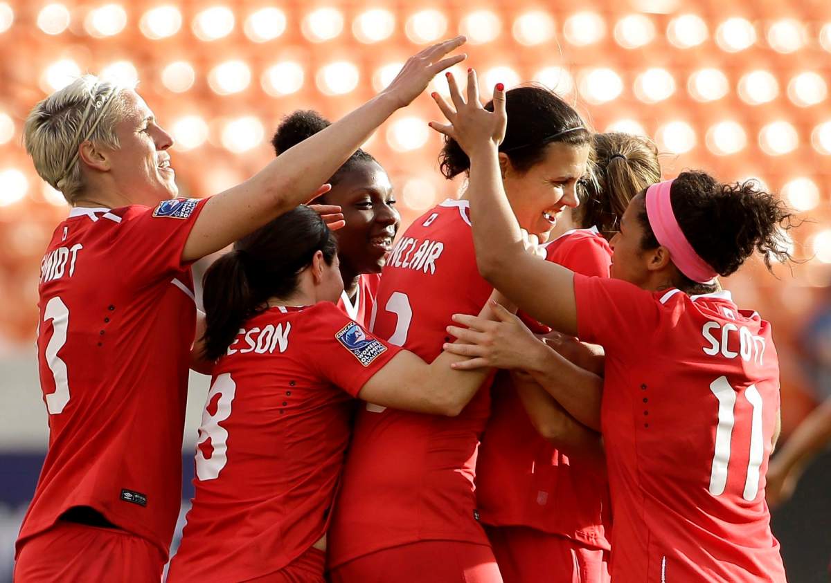 Canada's Christine Sinclair, center, is congratulated after scoring a goal against Trinidad & Tobago during the second half of a CONCACAF Olympic qualifying tournament soccer match Sunday, Feb. 14, 2016, in Houston. Canada won 6-0. 