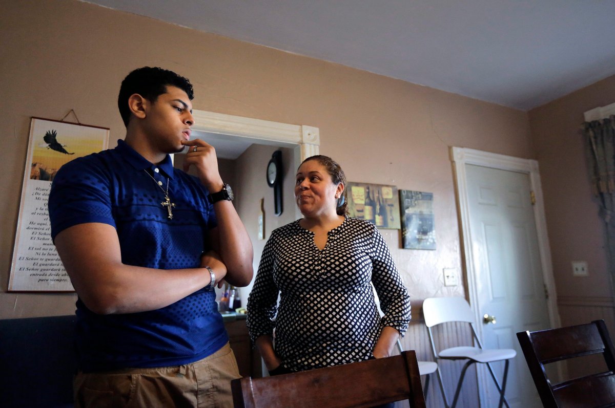 Jay Henriquez, 16, left, and his mother Lisa Solano-Sanchez, right, both of Providence, R.I., talk in the kitchen of their home, in Providence. Solano-Sanchez believes her son, who was born in July of 1999, was poisoned in 2000 by consuming paint chips containing lead from a window sill in the home of his grandmother. 