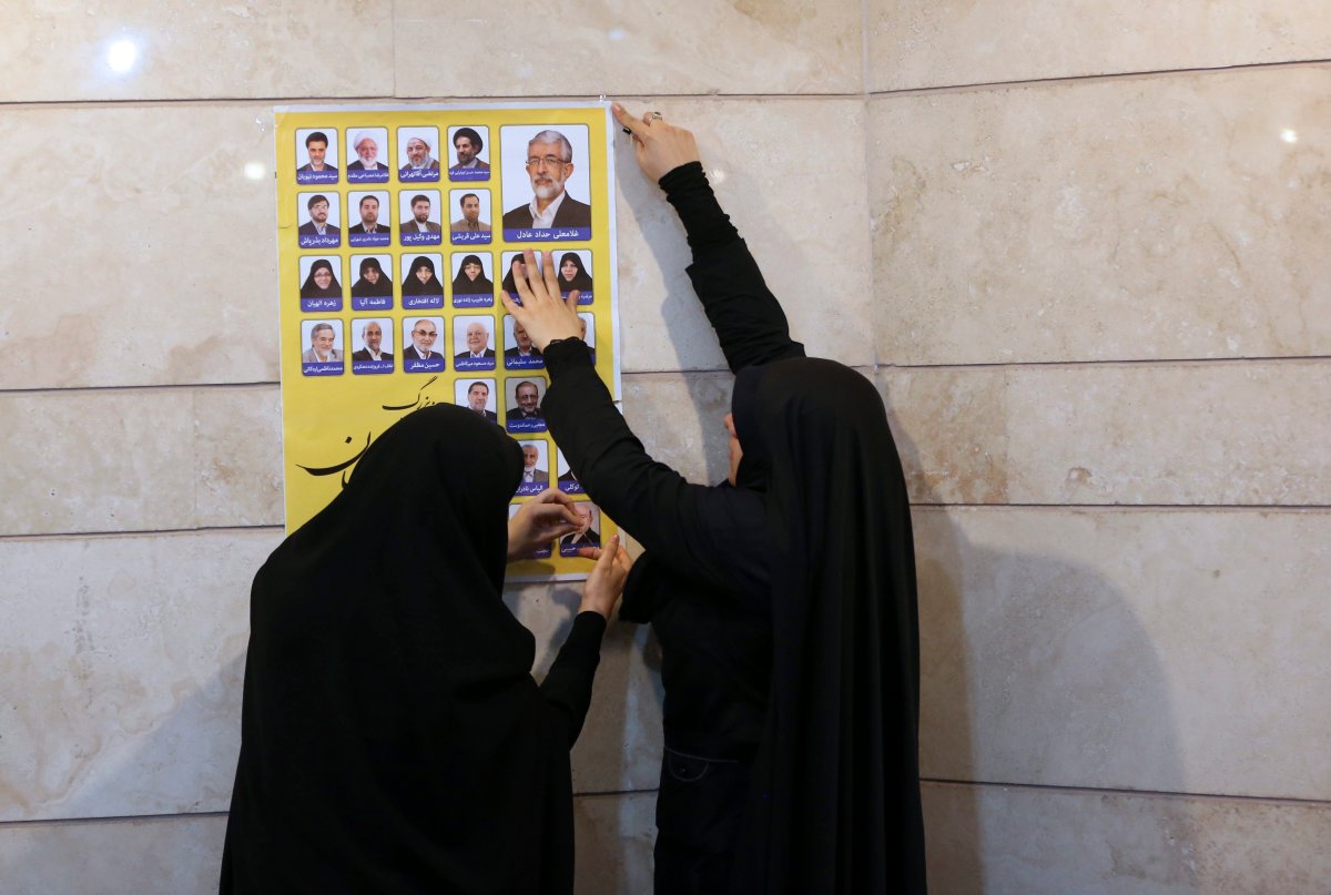 Election campaign workers paste an electoral poster, of a group of conservative candidates in the upcoming parliamentary elections, on a wall during a campaign gathering in Tehran, Iran, Sunday, Feb. 21, 2016. Iranians will hold elections for their 290-seat parliament on Feb. 26, while both reformists and conservatives have focused on improving the economic situation of the country, which is still feeling the effects of years of international sanctions. On the same day as parliamentary elections, voting will take place for Iran's 88-member clerical body known as the Assembly of Experts, which will one day pick a successor to 76-year-old Supreme Leader Ayatollah Ali Khamenei. (AP Photo/Vahid Salemi).