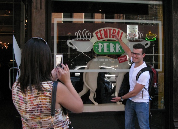 Tourists take photos outside a temporary "pop up" reproduction of the "Central Perk" coffee shop, a center piece set of the television situation comedy "Friends" in New York September 17, 2014.  