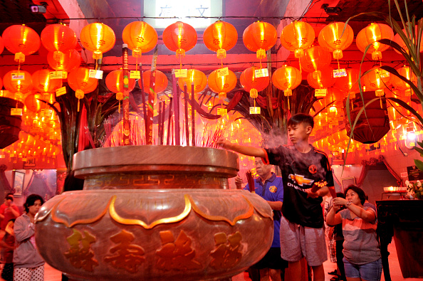 People pray and burn incense during the Chinese New Year eve at Boen San Bio temple. The Chinese New Year is the most important of the holidays for the Chinese.  (Photo by Yuan Adriles/Pacific Press/LightRocket via Getty Images).