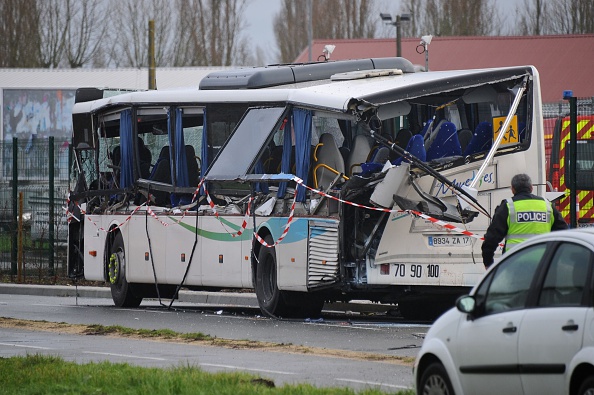 French police work near the wreckage of a school minibus after it crashed into a truck near Rochefort on February 11, 2016, killing at least six children, police said, a day after another road accident involving a school bus left two youngsters dead.
The head-on smash with a lorry carrying rubble came around 7:15 am (0615 GMT) near Rochefort in the western Charente-Maritime region.