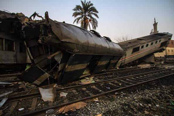Railway workers and rescue team members inspect the crash site after a passenger train hit a concrete barrier on the railway in Beni Suef, Egypt on February 11, 2016. (Photo by Ragy Maged/Anadolu Agency/Getty Images).