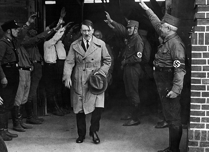 In this Dec. 5, 1931 file photo, Adolf Hitler, then leader of the National Socialists, is saluted as he leaves the party's Munich headquarters. 