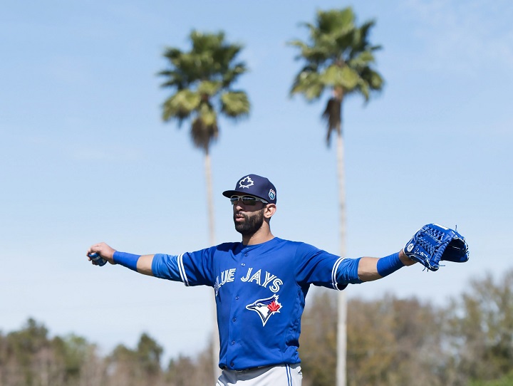 Toronto Blue Jays outfielder Jose Bautista stretches his arms as he walks up the field in the first official workout of spring training in Dunedin, Fla., on Monday February 22, 2016. 