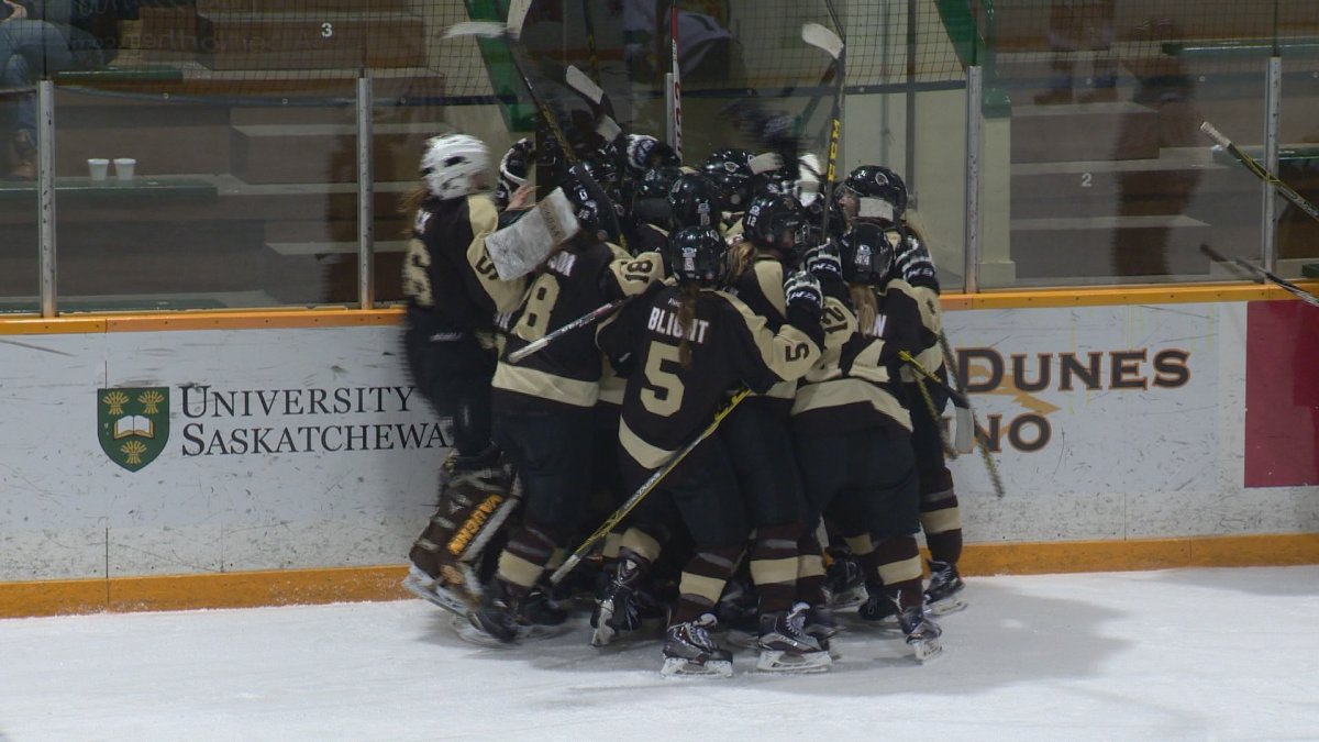 The Manitoba Bisons women's hockey team celebrates after winning in the fifth overtime period.