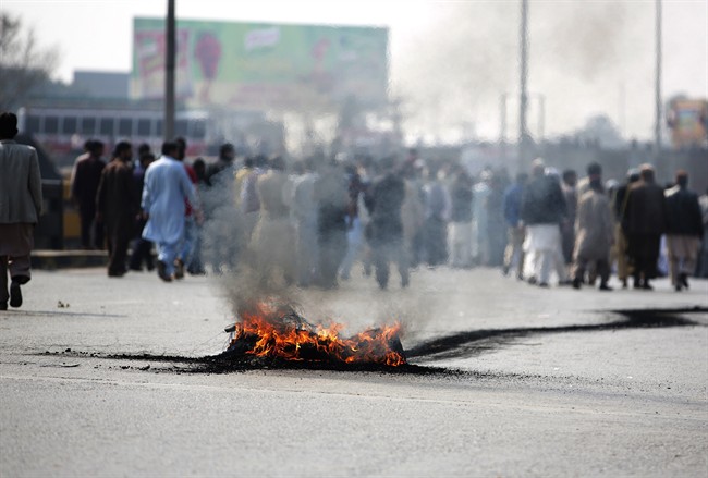 Pakistani protesters burn tires and block a main highway.