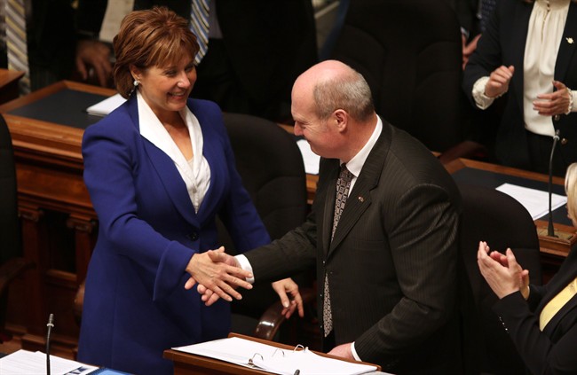 B.C. Finance Minister Michael de Jong shakes hands with Premier Christy Clark after delivering a balanced budget speech for a fourth year in a row at Legislative Assembly, in Victoria on Tuesday, Feb. 16, 2016.