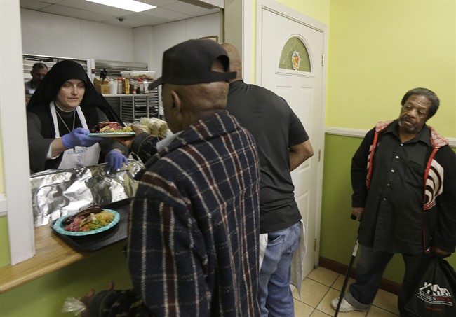 Sister Mary Benedicte, left, serves food at the Fraternite Notre Dame Mary of Nazareth Soup Kitchen in San Francisco, Tuesday, Feb. 9, 2016. 