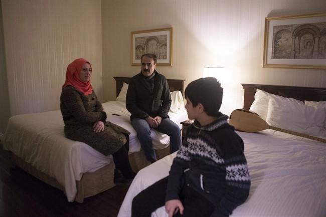 Syrian Kurdish refugees Dilaver Omar (centre) sits with his wife Dilsah Sahin (left) and their 11-year-old son Beyez Omar in their room at a Toronto hotel being used to house government sponsored refugees on Friday, January 29, 2016 as they wait to be housed in permanent accommodation.