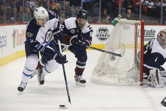 Winnipeg Jets centre Mark Scheifele wraps around the net for a shot as Colorado Avalanche left wing Gabriel Landeskog and goalie Semyon Varlamov defend during the second period of Saturday's game.