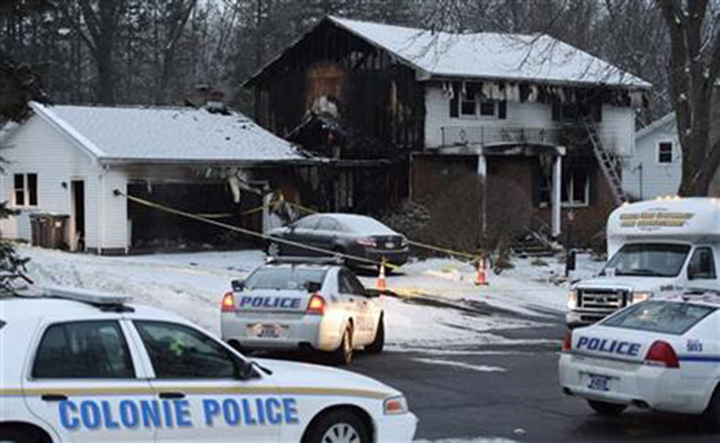 Law enforcement officials investigate a fatal fire, Wednesday, Feb. 10, 2016, in Colonie, N.Y. 