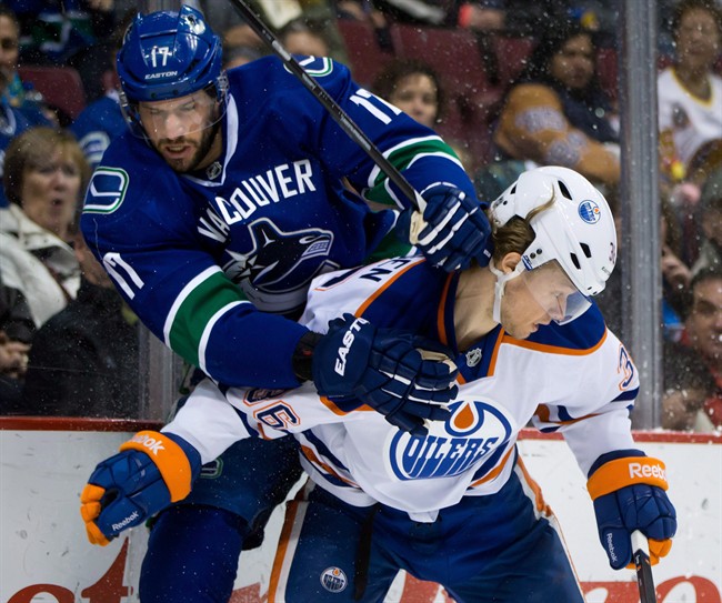 Vancouver Canucks' Ryan Kesler, left, and Edmonton Oilers' Philip Larsen, of Denmark, collide during first period NHL hockey action in Vancouver, B.C., on December 13, 2013. Defenceman Philip Larsen was acquired by the Vancouver Canucks in a trade with the Edmonton Oilers on Wednesday night. Edmonton gets a fifth round conditional pick in the 2017 NHL draft in return. THE CANADIAN PRESS/Darryl Dyck.