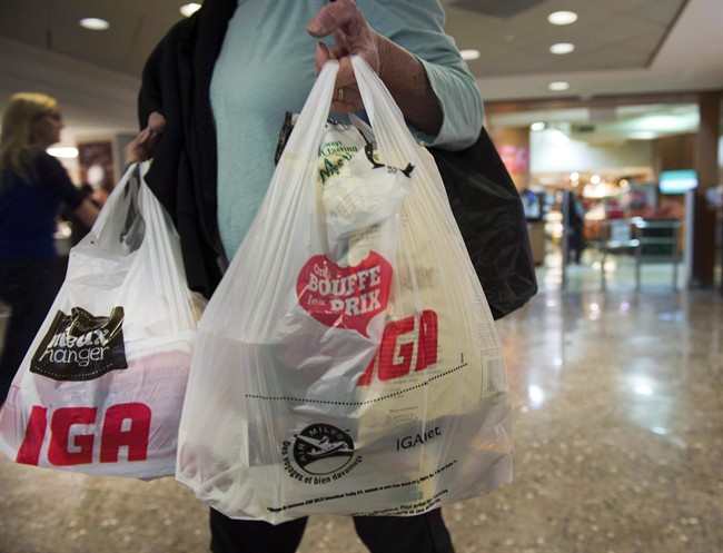 A woman leaves a grocery store Friday, May 15, 2015 in Montreal. The Canadian Plastic Bag Association has served the City of Brossard with a legal letter demanding it put a stop to its shopping-bag bylaw.