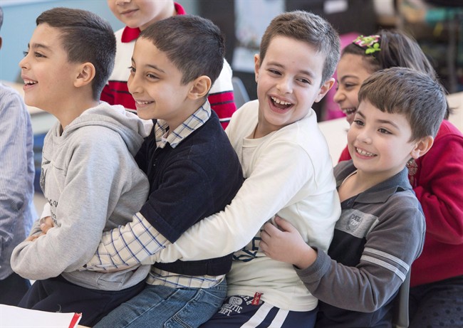 Syrian refugees Jamil Haddad, left, and Tony Batekh, 2nd left, George Louka and Edmon Artin, right, have some fun while they attend French classes at a school Wednesday, February 17, 2016 in Montreal. 