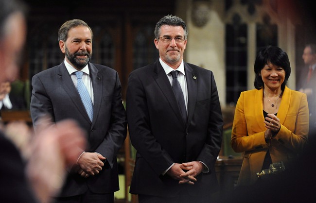 Newly-elected NDP MP Craig Scott is applauded as he is presented to the House of Commons by NDP Leader Tom Mulcair and MP Olivia Chow on Parliament Hill in Ottawa on Thursday, March 29, 2012. 