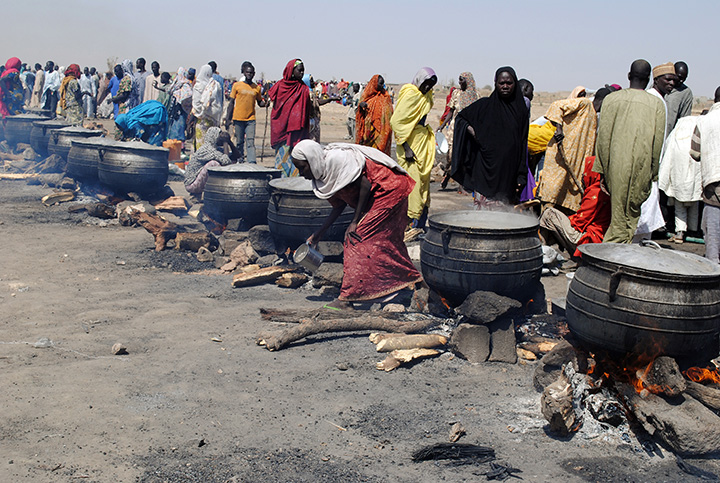 Women cook in pots heated up with firewood at an Internally Displaced Persons (IDP) camp at Dikwa, in Borno State in north-eastern Nigeria, on February 2, 2016. 