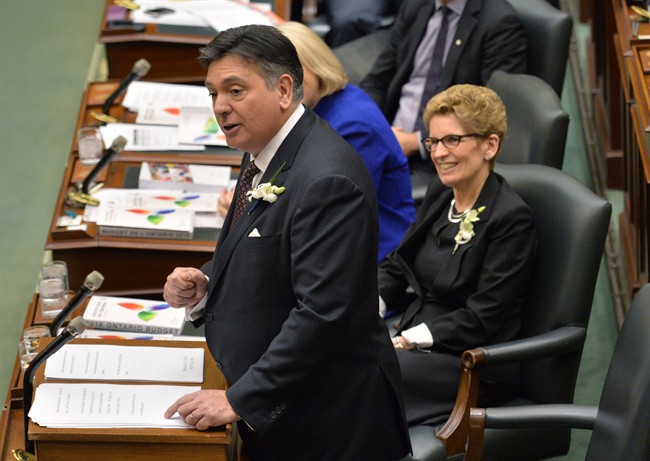 Ontario Finance Minister Charles Sousa, left, delivers the Ontario 2016 budget next to Premier Kathleen Wynne, right, at Queen's Park in Toronto on Thursday, February 25, 2016. 