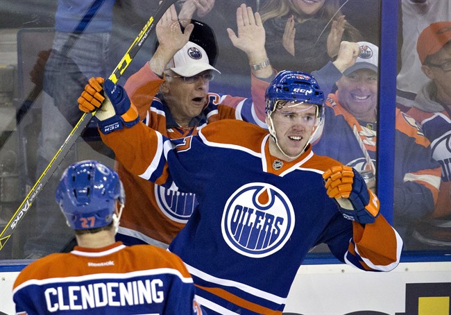 Edmonton Oilers' Connor McDavid (97) and Adam Clendening (27) celebrate McDavid's goal against the Columbus Blue Jackets during second period NHL action in Edmonton, Alta., on Tuesday February 2, 2016. 