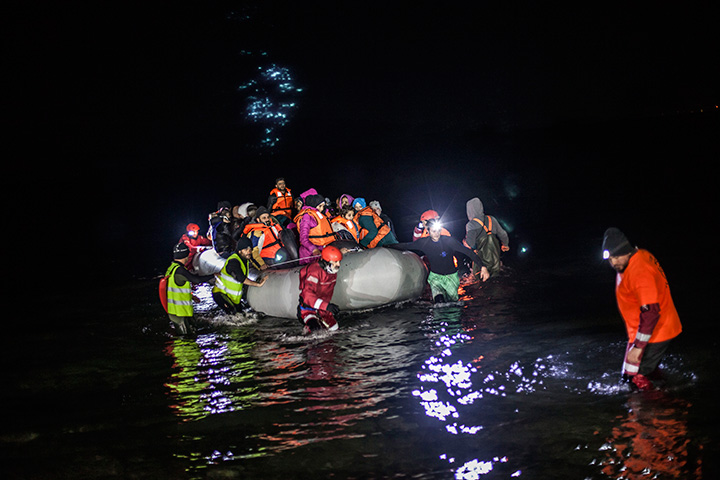 Refugees and migrants helped by volunteers after their arrival on a dinghy from the Turkish coast to the northeastern island of Lesbos, Greece Monday, Feb. 22, 2016. 