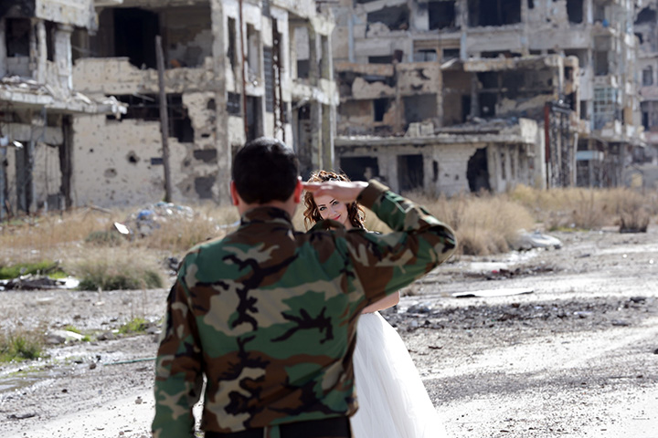 Newlywed Syrian couple Nada Merhi, 18, and Syrian army soldier Hassan Youssef, 27, pose for a wedding picture amid heavily damaged buildings in the war ravaged city of Homs on February 5, 2016. 